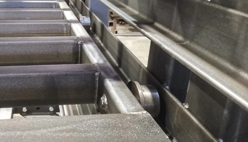 Close-up detail of heavy-duty bearing roller inside C-channel guide rail of sheet rack drawer